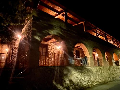 un antiguo edificio de piedra con ventanas por la noche en Complejo Rural La Glorieta, en Catí