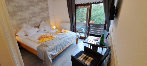 a bedroom with a bed with yellow sheets and a window at Quellenhof Altenau in Altenau