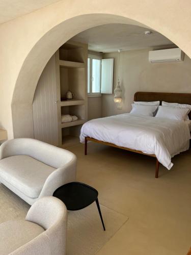 een slaapkamer met een groot bed en een stoel bij Casa dos Mercados in Olhão