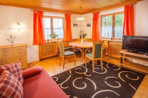 ein Wohnzimmer mit einem Tisch und einem TV in der Unterkunft Ferienwohnung Schmid in Brixen im Thale