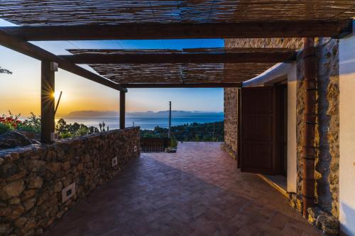 a view from the patio of a house with a stone wall at Alla Riserva - Villa Riserva dello Zingaro - Scopello in Scopello