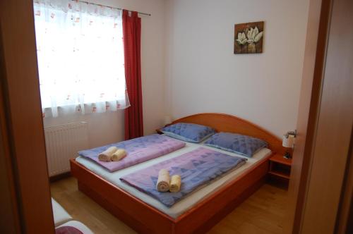 a bedroom with a bed with two pillows and a window at Apartments Blažič in Kranjska Gora