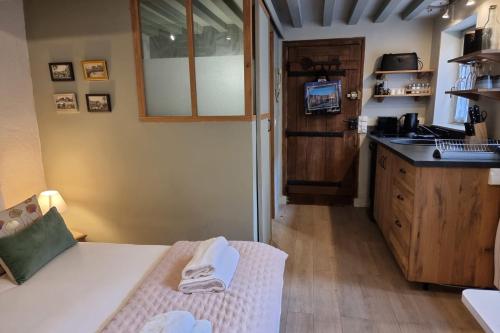 Cette chambre comprend une cuisine avec un évier et une table. dans l'établissement The Saint Jean Suite - Cozy for 2 - Center Honfleur with fireplace, à Honfleur