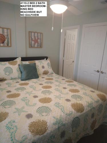 a bedroom with a bed with a comforter on it at Gulf Shores Plantation Condos in Gulf Shores