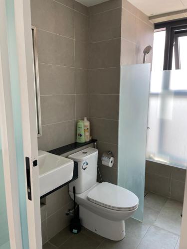 ein Badezimmer mit einer weißen Toilette und einem Waschbecken in der Unterkunft The Aspen, 3BR Cityview by WStay @Tropicana 218 Macalister in George Town