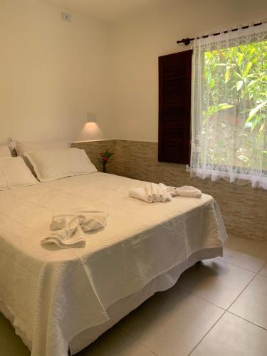 um quarto com uma cama com duas toalhas em Pousada Chale Cana Brava em Guaramiranga