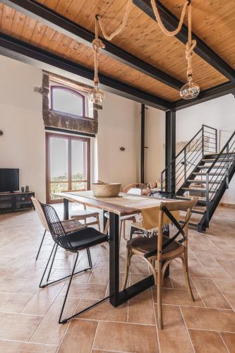 a dining room with a table and chairs and a staircase at Alla Riserva - Villa Riserva dello Zingaro - Scopello in Scopello