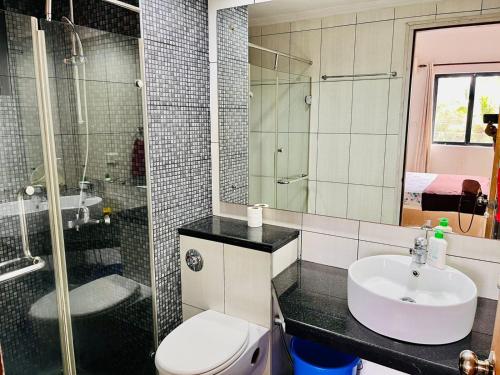 a bathroom with a toilet and a sink and a shower at Pool and Garden Facing Apartment in Riviera Foothills Near Baga, Arpora in Arpora