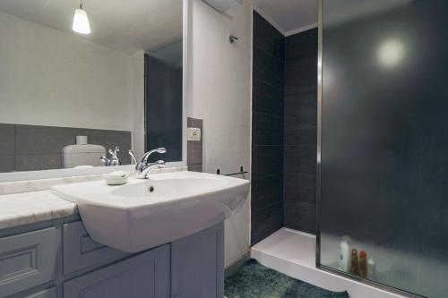 W łazience znajduje się biała umywalka i prysznic. w obiekcie Una Civetta sul Lago w Alleghe