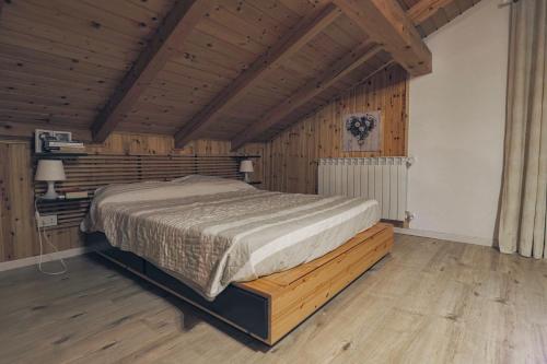 a bedroom with a bed in a wooden room at Una Civetta sul Lago in Alleghe