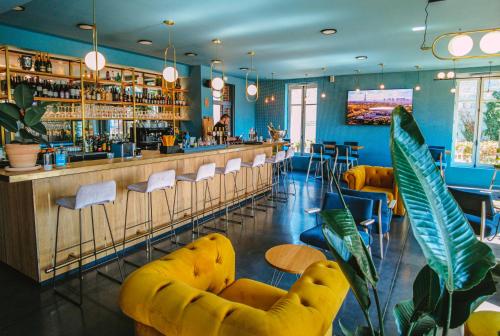 ウーにあるMayrena Hotel Restaurantの黄色い椅子とバーのあるレストラン