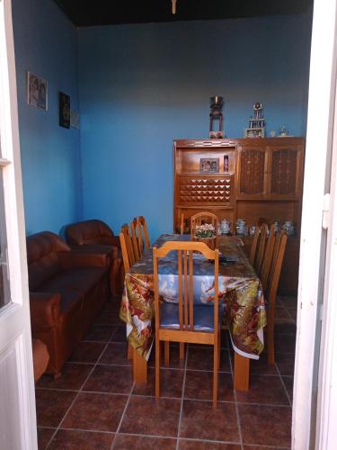 uma sala de jantar com uma mesa e cadeiras e um sofá em Casa Ituzaingó em Minas