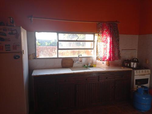 a kitchen with a sink and a window in it at Casa Ituzaingó in Minas