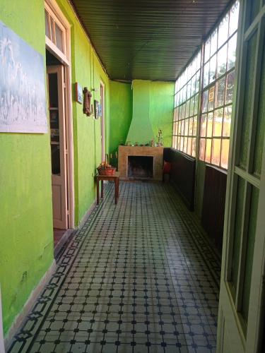 Habitación vacía con paredes verdes y chimenea en Casa Ituzaingó, en Minas