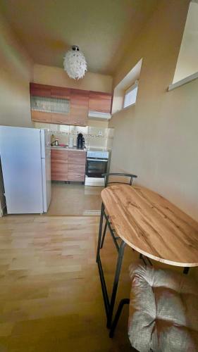 Garzon/ Studio apartment في Šahy: مطبخ مع طاولة وثلاجة بيضاء