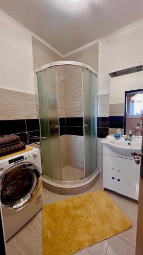 ein Bad mit einer Dusche und einer Waschmaschine in der Unterkunft Garzon/ Studio apartment in Šahy