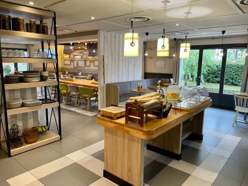 - une cuisine avec comptoir et vaisselle dans l'établissement Campanile Villepinte - Parc des Expositions, à Villepinte