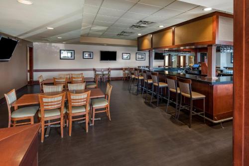 a restaurant with wooden tables and chairs and a bar at Holiday Inn Bangor by IHG in Bangor
