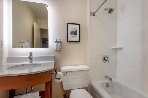 a bathroom with a sink and a toilet and a tub at Holiday Inn Bangor by IHG in Bangor