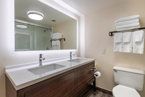 a bathroom with a sink and a toilet and a mirror at Holiday Inn Bangor by IHG in Bangor
