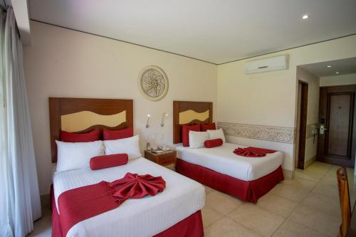 a hotel room with two beds with red bows on them at Hosteria Las Quintas Hotel Restaurante Bar in Cuernavaca