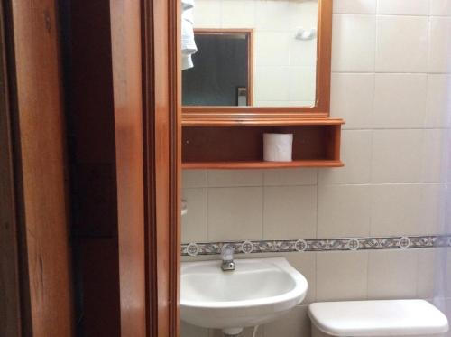 a bathroom with a sink and a mirror and a toilet at El Prado EcoHotel in Montenegro