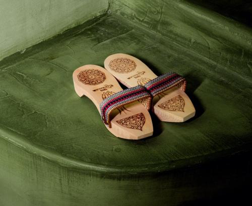 a pair of wooden shoes sitting on a green plate at Hôtel La Nouvelle République & Hammam in Paris