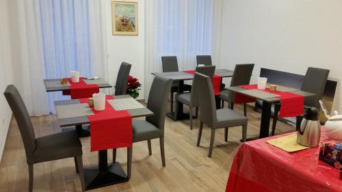 a dining room with tables and chairs with red bows at Casa Mafalda in Chioggia