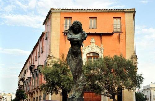 Una statua di una donna davanti a un edificio di Miriam Costa de la luz 2 a Jerez de la Frontera