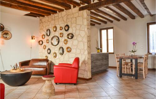a living room with a red chair and a stone wall at Beautiful Home In Saulchery With Wifi in Saulchery