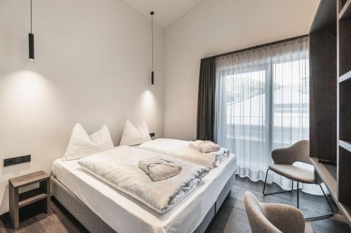 a hotel room with a large bed and a large window at Aquila Dolomites Residence in Ortisei