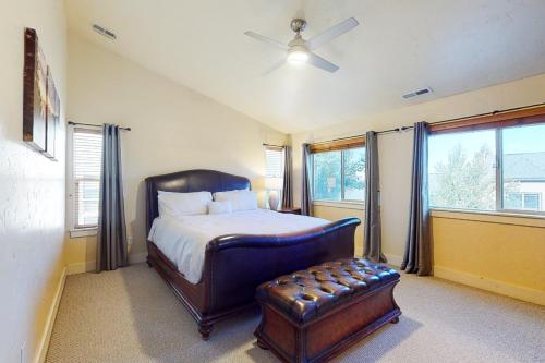 a bedroom with a bed and a chair and windows at Bear Hollow Villa in Park City