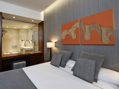 a hotel room with a bed and a bathroom at Hotel Carris Marineda in A Coruña