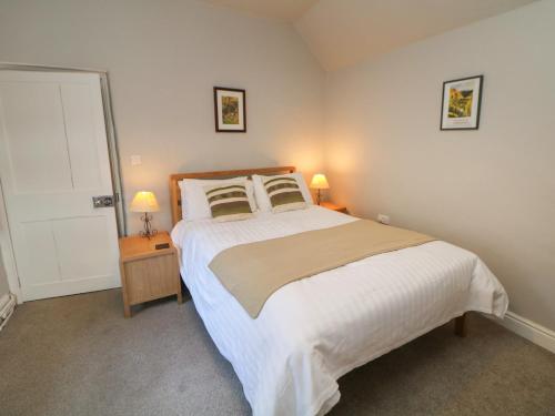 - une chambre avec un grand lit et deux lampes dans l'établissement East Bank Cottage, à Matlock