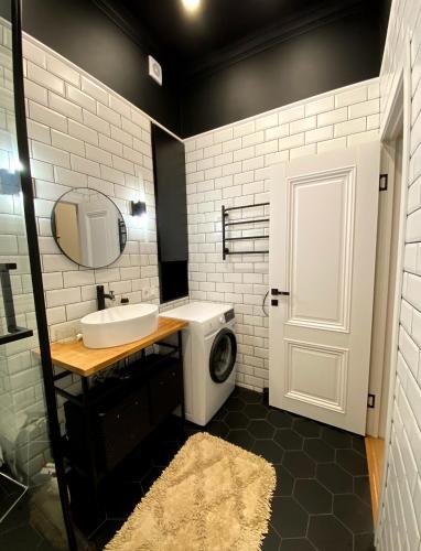 La salle de bains est pourvue d'un lavabo et d'un lave-linge. dans l'établissement Квартира студия, à Almaty