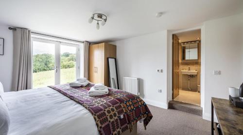 a bedroom with a bed and a large window at Romantic Getaway - Mountain View -Ty Cerrig Barn in Corwen