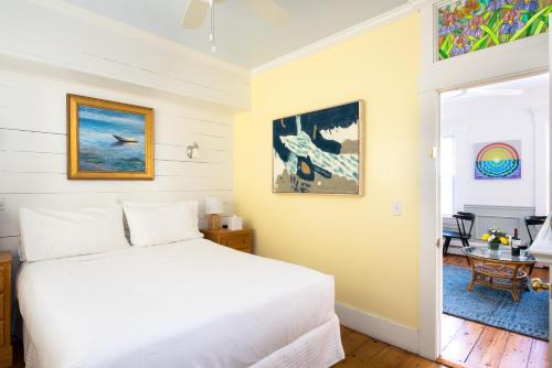 a bedroom with a white bed and a table at Admiral's Landing in Provincetown