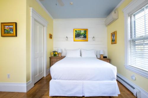 a bedroom with a white bed and a window at Admiral's Landing in Provincetown