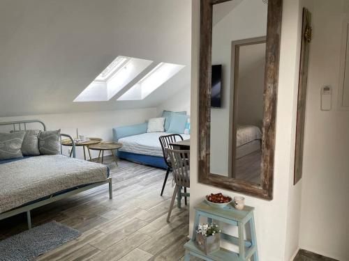a room with a mirror and a bed and a table at Srní-Modrý podkroví byt /dvojdomek u hotelu Vydra in Srní