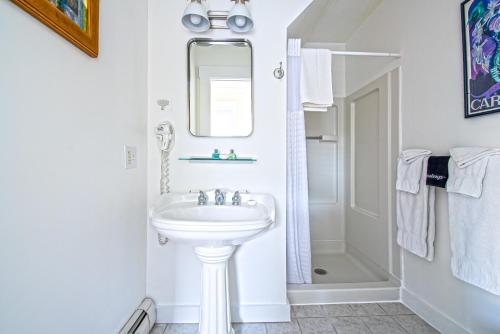 a white bathroom with a sink and a mirror at Admiral's Landing in Provincetown