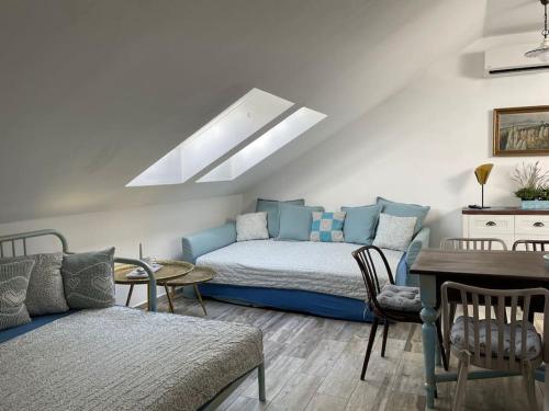 1 dormitorio con cama, sofá y mesa en Srní-Modrý podkroví byt /dvojdomek u hotelu Vydra, en Srní