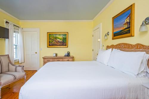 a bedroom with a large white bed and a couch at Admiral's Landing in Provincetown