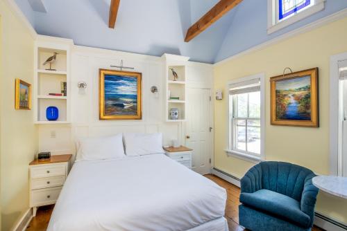 um quarto com uma cama e uma cadeira azul em Admiral's Landing em Provincetown