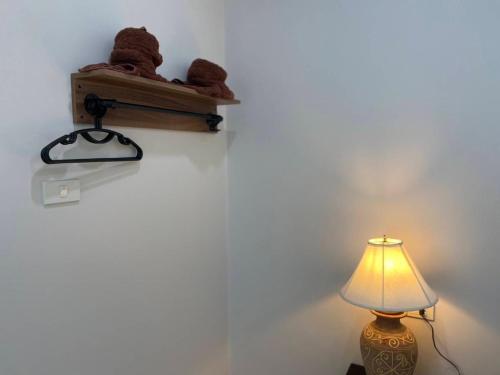 a teddy bear sitting on a shelf next to a lamp at MONDEE House @The Airport in Thalang