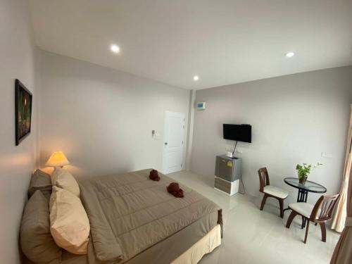 MONDEE House @The Airport في تالانغ: غرفة نوم مع سرير مع دمية دب عليها