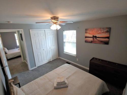 um quarto com uma cama e uma ventoinha de tecto em Relaxing Cottage by the Lake and Parking em Pontiac