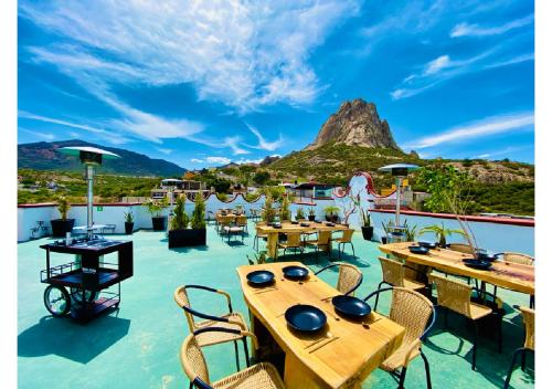 a patio with tables and chairs with a mountain in the background at Hotel Hacienda Real in Querétaro