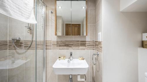 a white bathroom with a sink and a shower at Stunning Barn Conversion with HOT TUB and ALPACAS - Ty Cerrig Barn in Corwen