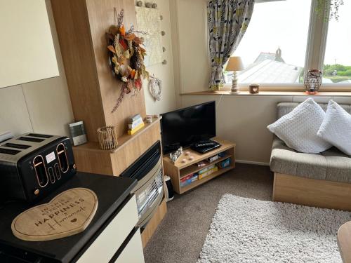 a small kitchen with a stove and a couch at Barmouth Pet-Friendly 2-Bed Caravan with Sea View in Barmouth