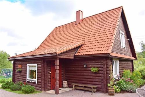 a small log cabin with a bench in front of it at Sodyba Sauletekis in Ignalina